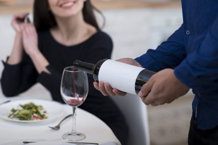 Homme versant du vin dans un verre pour sa femme